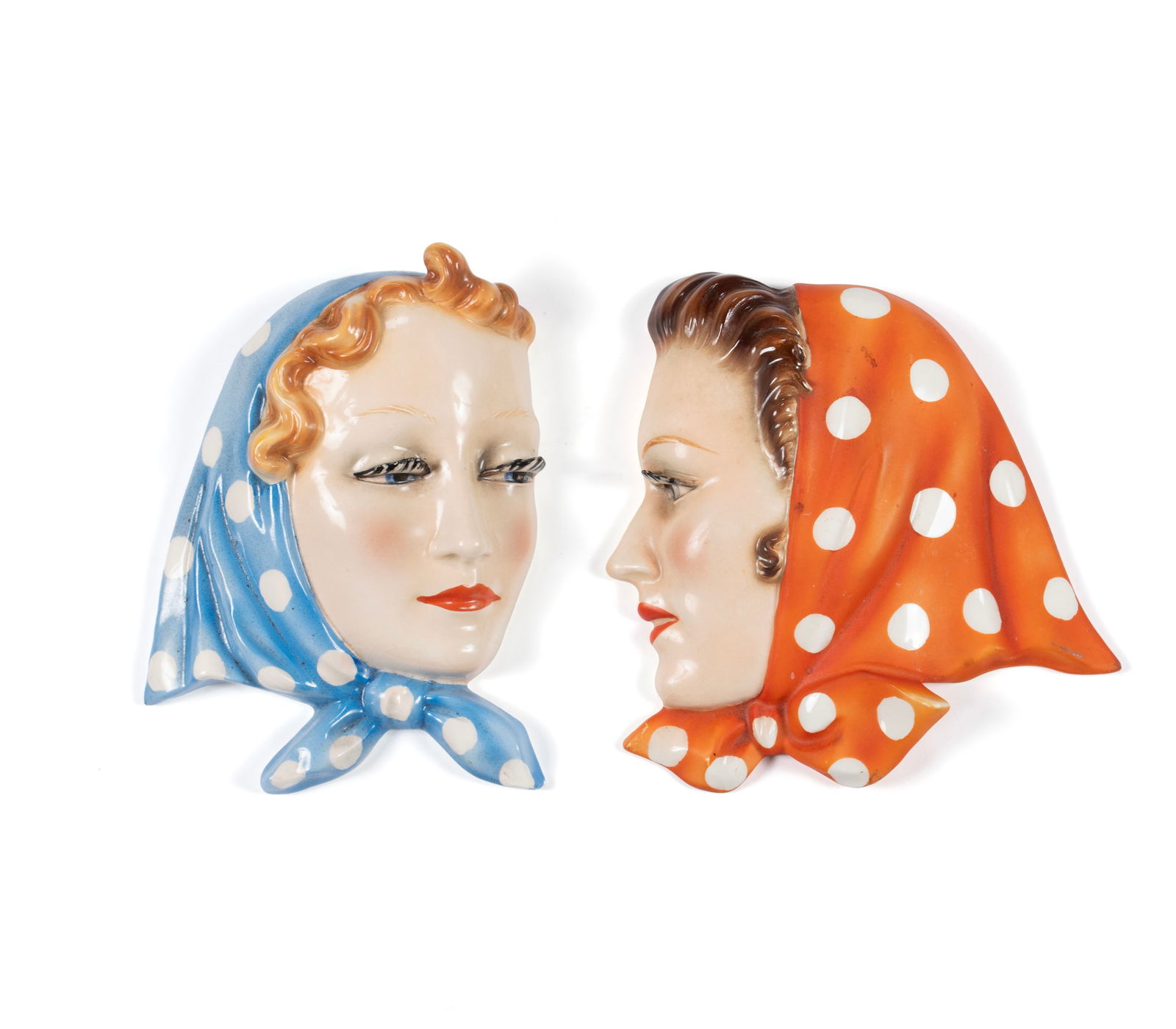 TWO GOEBEL ART DECO WALL PORTRAITS: TWO GOEBEL ART DECO WALL PORTRAITS German, circa 1930s, porcelain. Two women, one wearing a red scarf, the other a blue scarf, Goebel shape numbers 144 and 145. 7 1/2 x 5.70 in. (19.1 x 14.5 cm.)