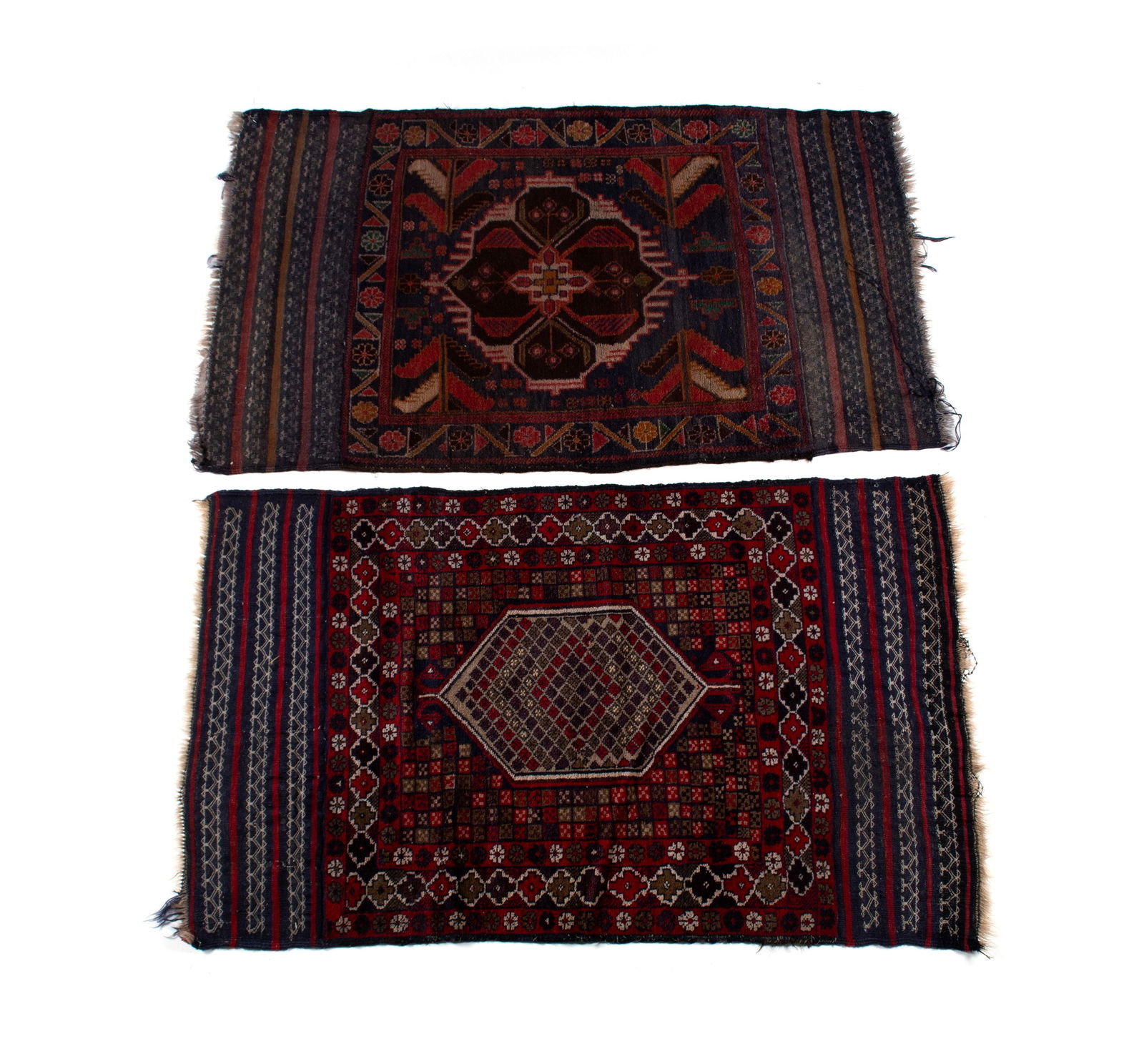 TWO BALUCH THROW RUGS: TWO BALUCH THROW RUGS Persian, 20th century. Foliate and floral designs to the navy ground on one, the other with geometric forms on a red ground, both with extended flatweave end panels. Both near 4