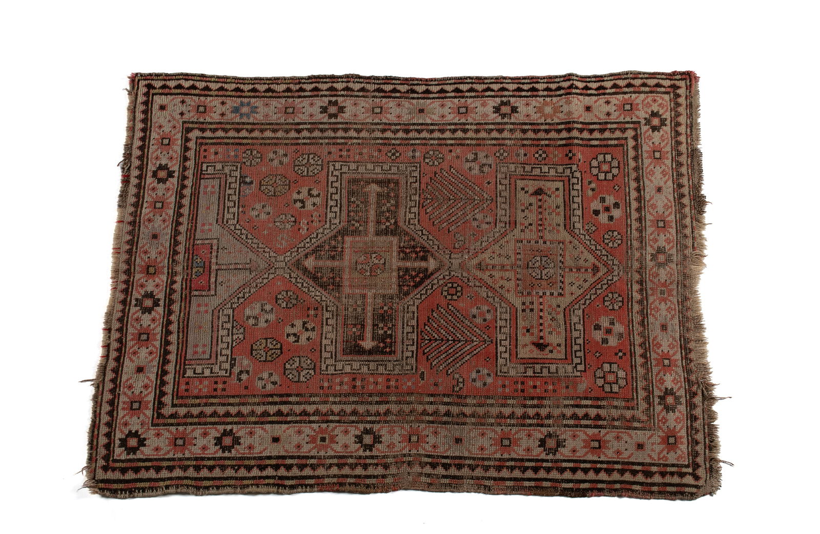 CAUCASIAN AREA RUG: CAUCASIAN AREA RUGPersian, early 20th century, low woven pile. Large geometric medallions on the soft red field with additional foliate highlights, ivory border with saw tooth guard borders, shows wea