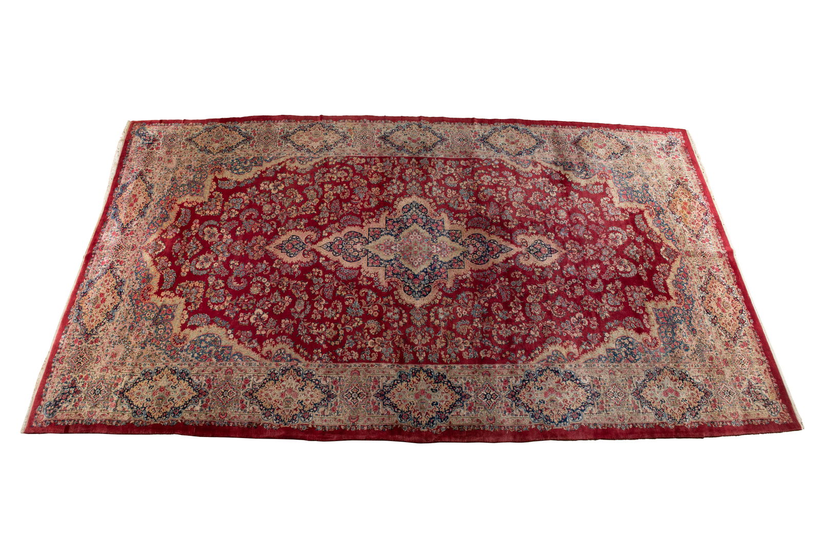 KERMAN ROOM RUG: KERMAN ROOM RUGPersian, circa 1960. Colorfully floral decorated celadon and red on navy pole medallion centers the red field covered with flowering vines with celadon and royal blue end panels/corners