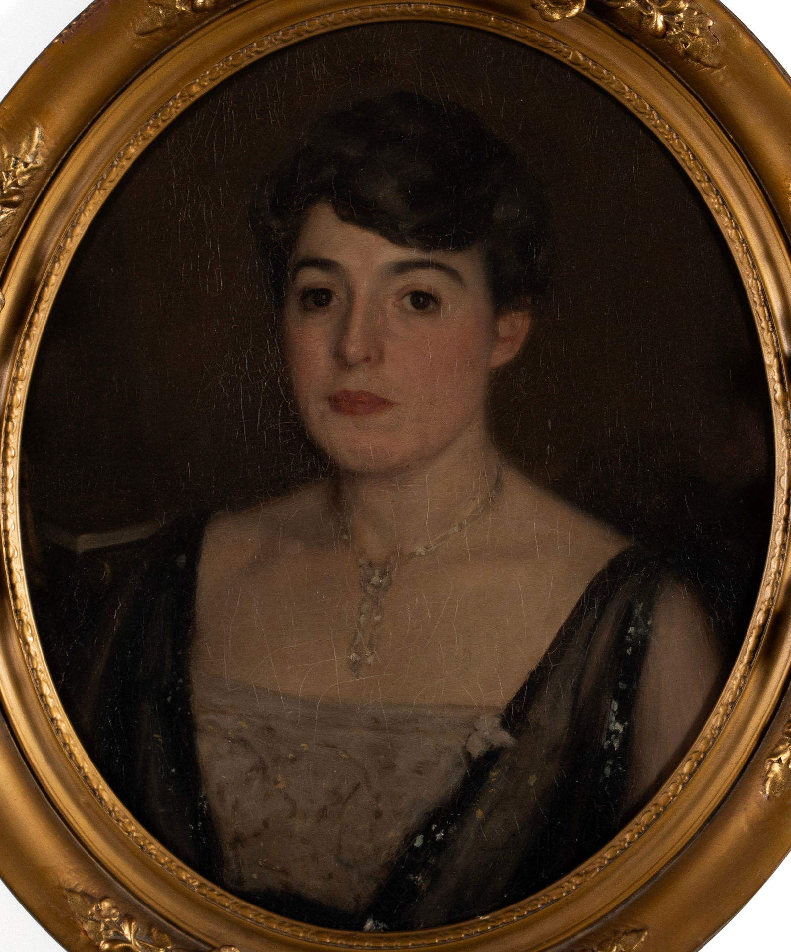 PORTRAIT OF A WOMAN: PORTRAIT OF A WOMAN 20th century, oil on board. Formal portrait of a short haired brunette, within a gilt frame. 20 3/4 x 17 1/4 in. (52.7 x 43.8 cm.), Frame: 27 1/4 x 24 in. (69.2 x 61 cm.)