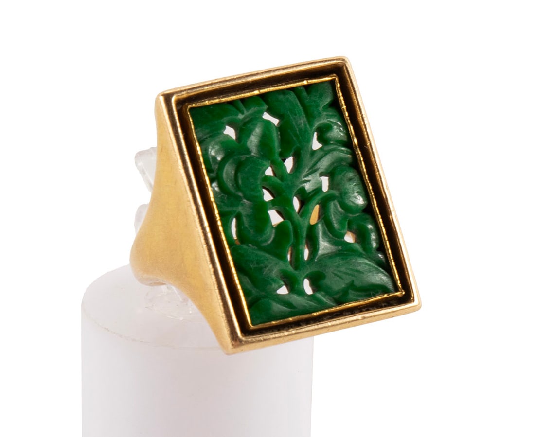 GOLD AND JADE RING: GOLD AND JADE RINGAn unmarked 14k yellow gold (acid tested) ring. With inset foliate carved jadeite panel.Size: 6; weight: 14 grams