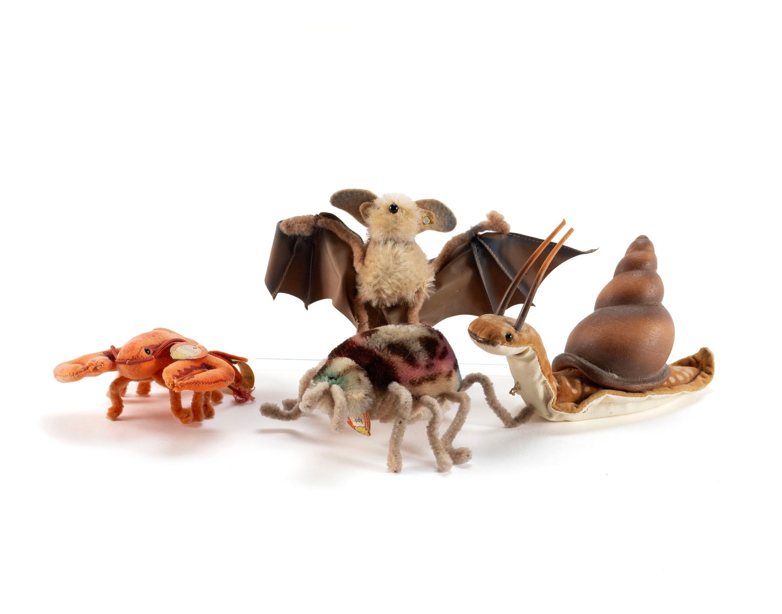 FOUR STEIFF ANIMALS: FOUR STEIFF ANIMALSGerman, 20th century. Includes a bat with yellow label held by button, "Crabby" the crab with original circular Steiff paper tag and yellow label held by button, "Spidy" the spider