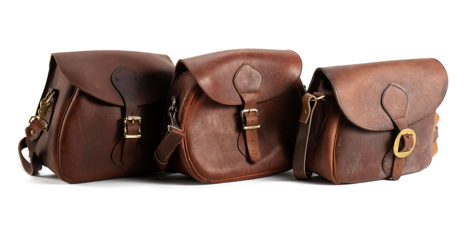 THREE LEATHER GAME HUNTING SHOULDER BAGS: THREE LEATHER GAME HUNTING SHOULDER BAGSAmerican, 20th century. Two with "GOKEY" labels and another unmarked, with brass hardware and shoulder straps.Largest: 9 x 11 x 5 in. (22.9 x 27.9 x 12.7 cm.)