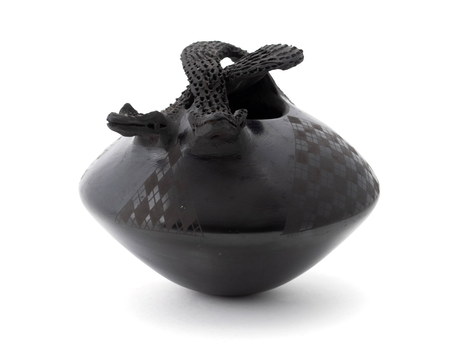 JOSE QUEZADA MATA ORTIZ POT: JOSE QUEZADA MATA ORTIZ POT Mexican, 20th century. Blackware pot with twisted rattlesnake handles, signed on underside. Lot also includes an associated ceramic stand. 6 x 8 in. (15.2 x 20.3 cm.)