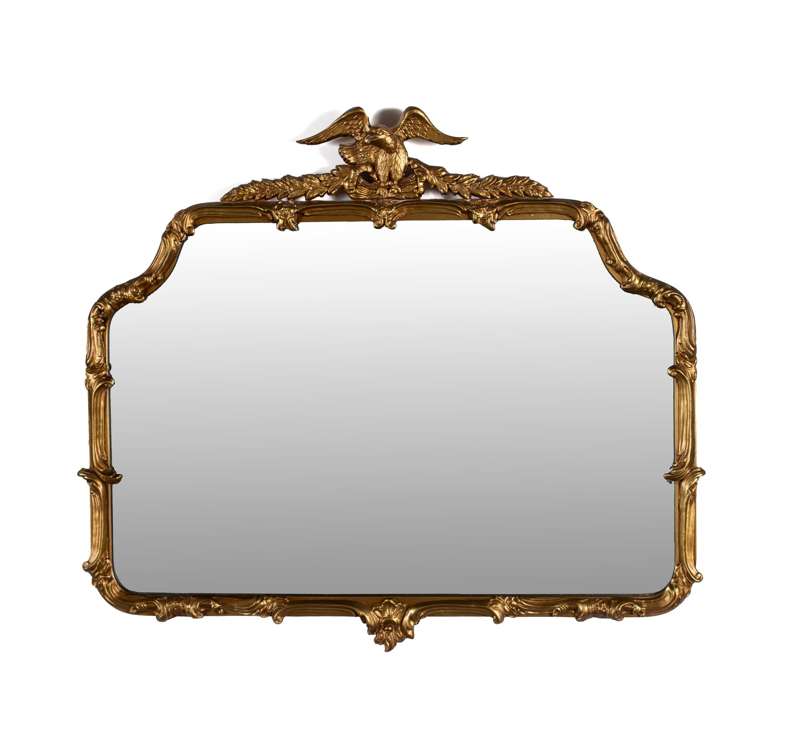 GILT FRAMED WALL MIRROR: GILT FRAMED WALL MIRROR American, mid-20th century. Scrolling and foliate decorated wood and gesso frame with full eagle crest. 34 x 39 1/4 in. (86.4 x 99.7 cm.)