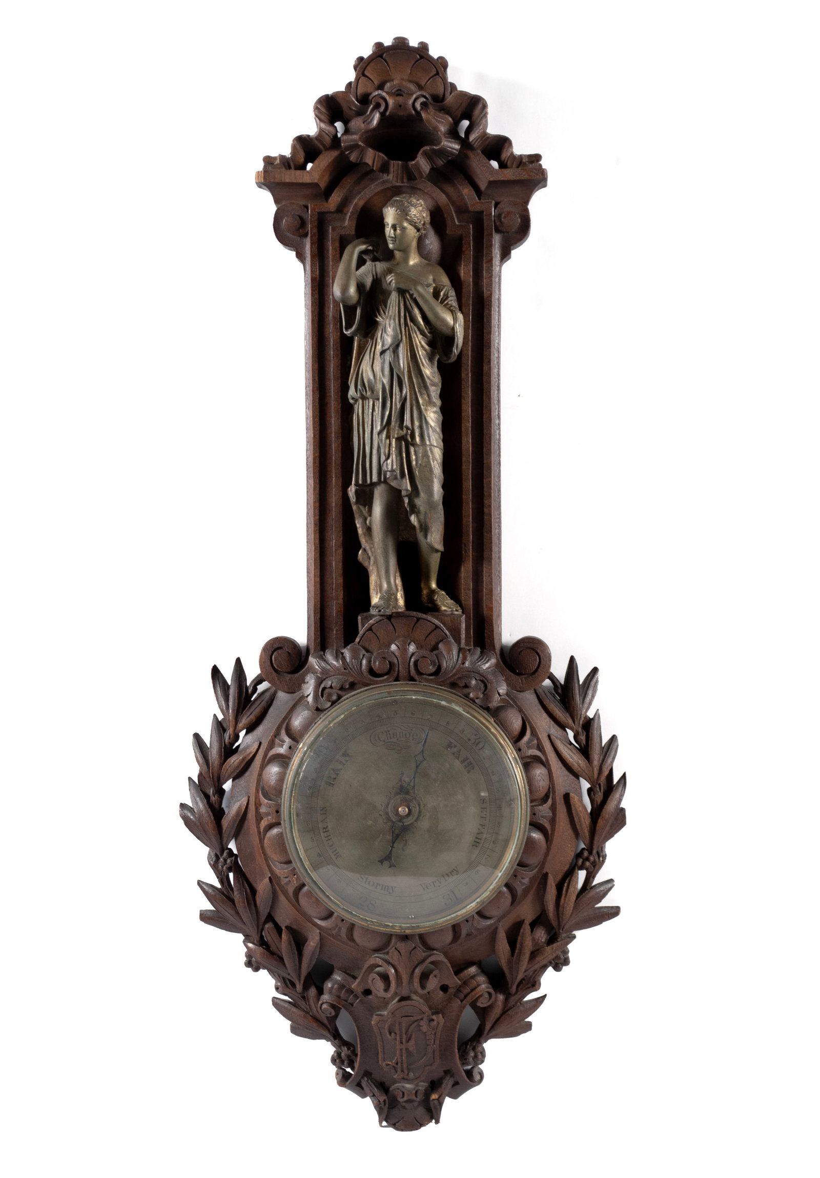 BLACK FOREST STYLE CARVED OAK BAROMETER: BLACK FOREST STYLE CARVED OAK BAROMETER 20th century. Carved oak barometer with metal figure of a Classical woman. 38 x 16 x 5 in. (96.5 x 40.6 x 12.7 cm.)