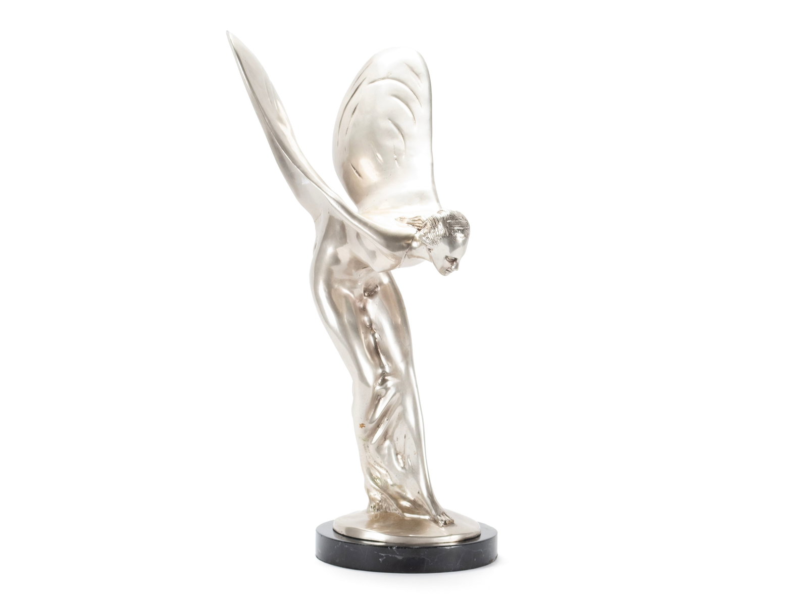 SPIRIT OF ECSTASY IN THE MANNER OF SYKES: SPIRIT OF ECSTASY IN THE MANNER OF SYKES White metal, unsigned. An image in the manner of Charles Sykes, of his famous winged car mascot, on black marble base. 20 1/4 in. (51.4 cm.)