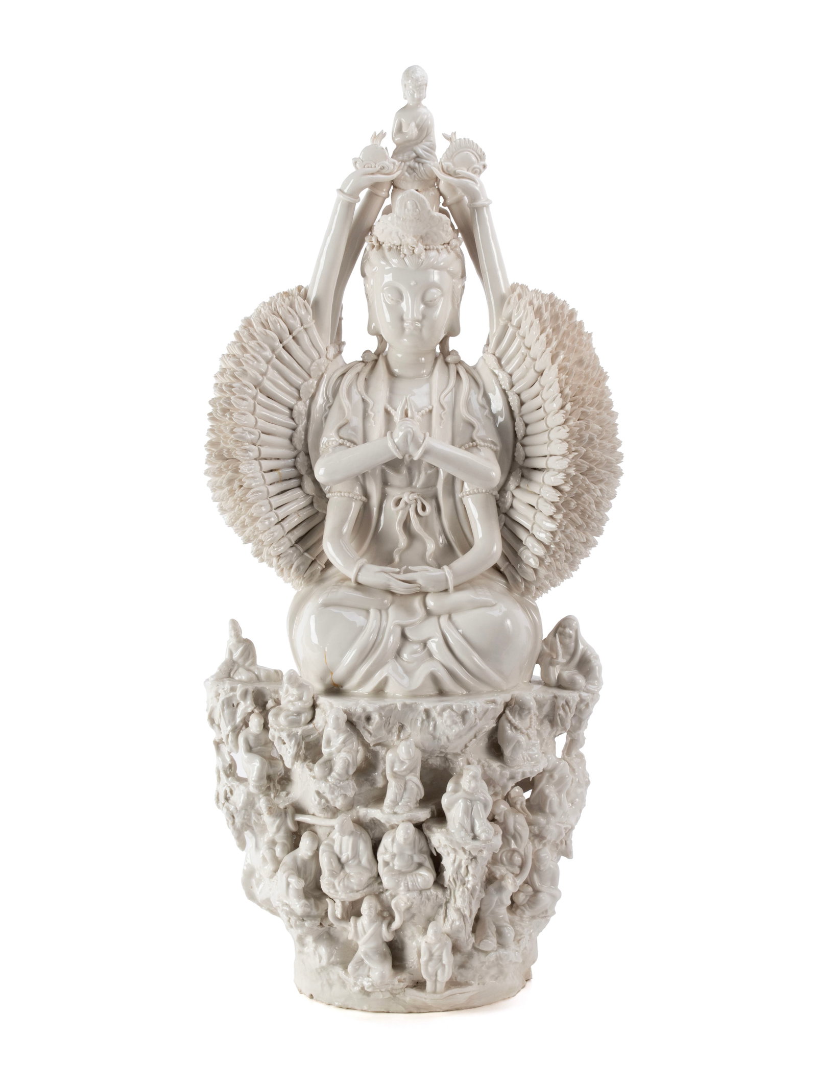 BLANC DE CHINE BODHISATTVA: BLANC DE CHINE BODHISATTVA Chinese, 20th century. Depicts Quan Yin, the goddess of compassion, in the thousand-arm form, with a Buddha figure a top her head, seated on a rocky base surrounded by