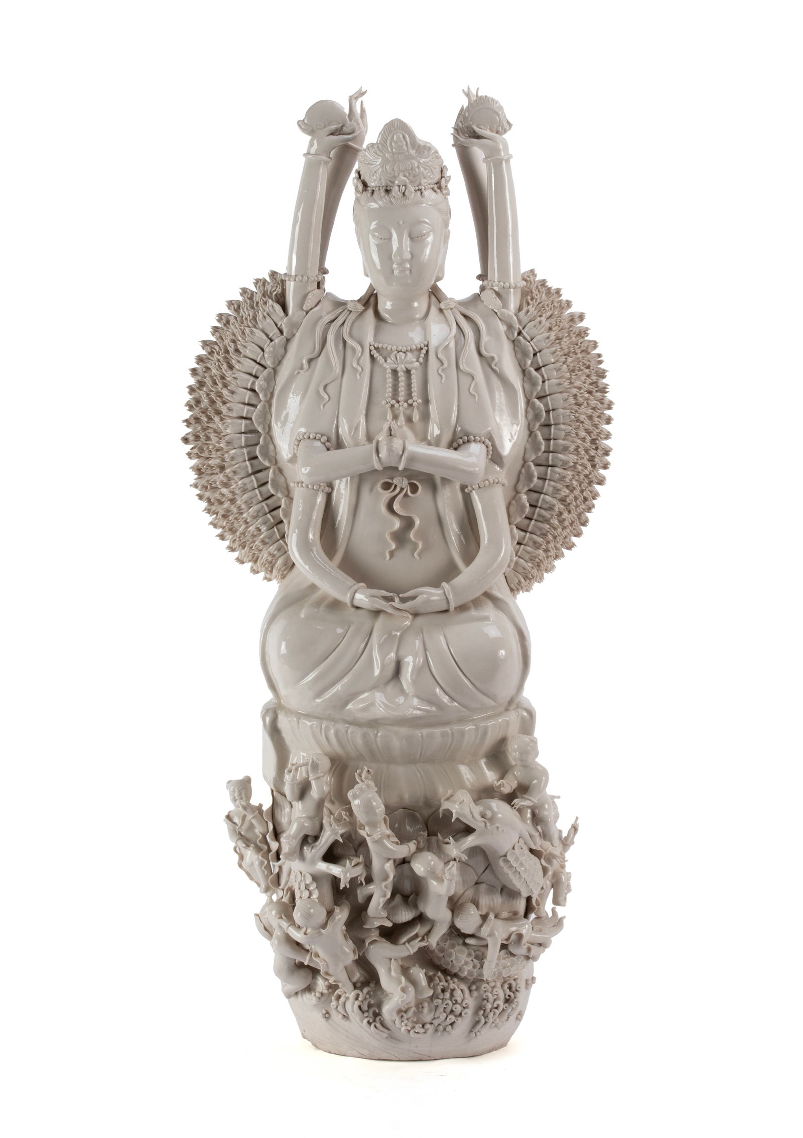 BLANC DE CHINE BODHISATTVA: BLANC DE CHINE BODHISATTVA Chinese, 20th century. Depicts Quan Yin, the goddess of compassion, in the thousand-arm form, seated on a lotus base surrounded by a dragon and figures. 30 1/2 x 14 in.