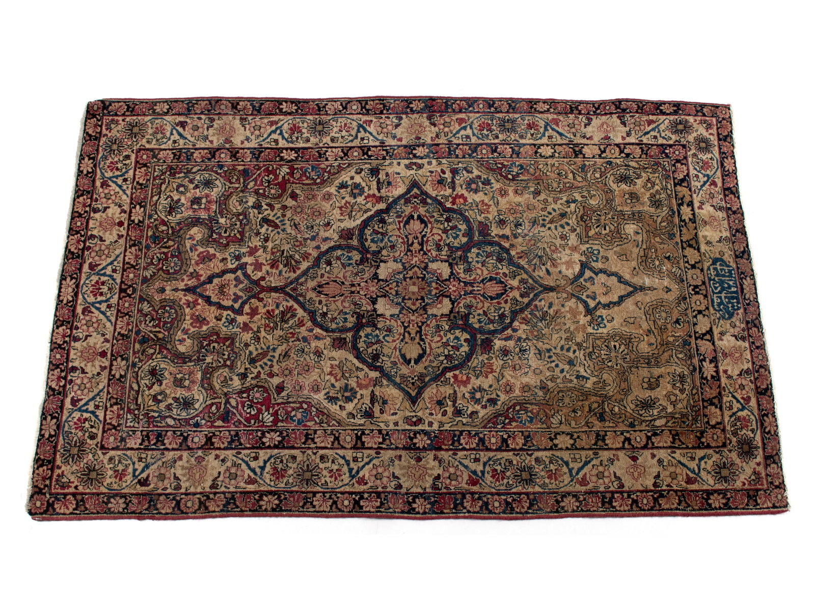 DILMAGHANI KERMAN AREA RUG: DILMAGHANI KERMAN AREA RUG Persian, early 20th century, signed. Large navy on ivory foliate pole medallion with red highlights centers the floral decorated ivory field with ivory on red corners, ivory