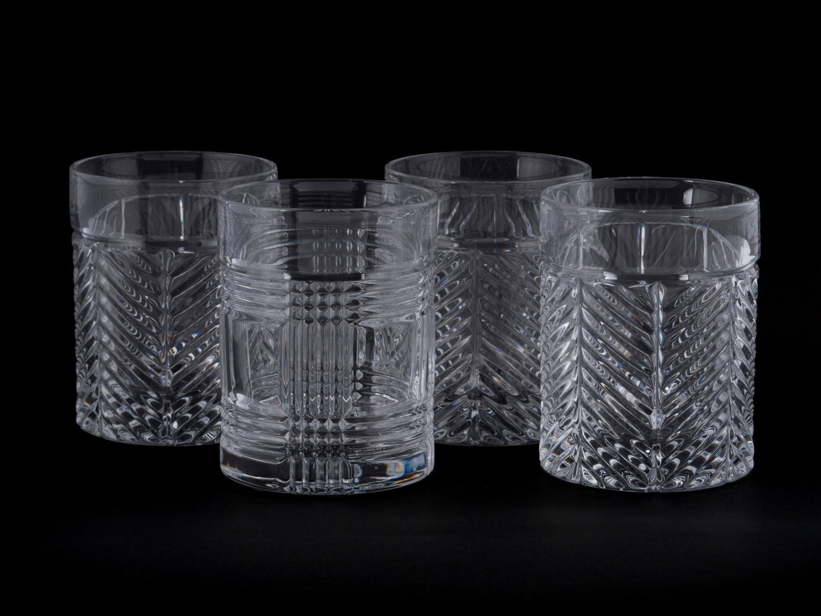 FOUR RALPH LAUREN OLD FASHIONED GLASSES: FOUR RALPH LAUREN OLD FASHIONED GLASSES Including three (3) in the Herringbone pattern and one (1) in the Glen Plaid pattern. With etched marks to underside. 4 1/2 x 3 in. (11.4 x 7.6 cm.)