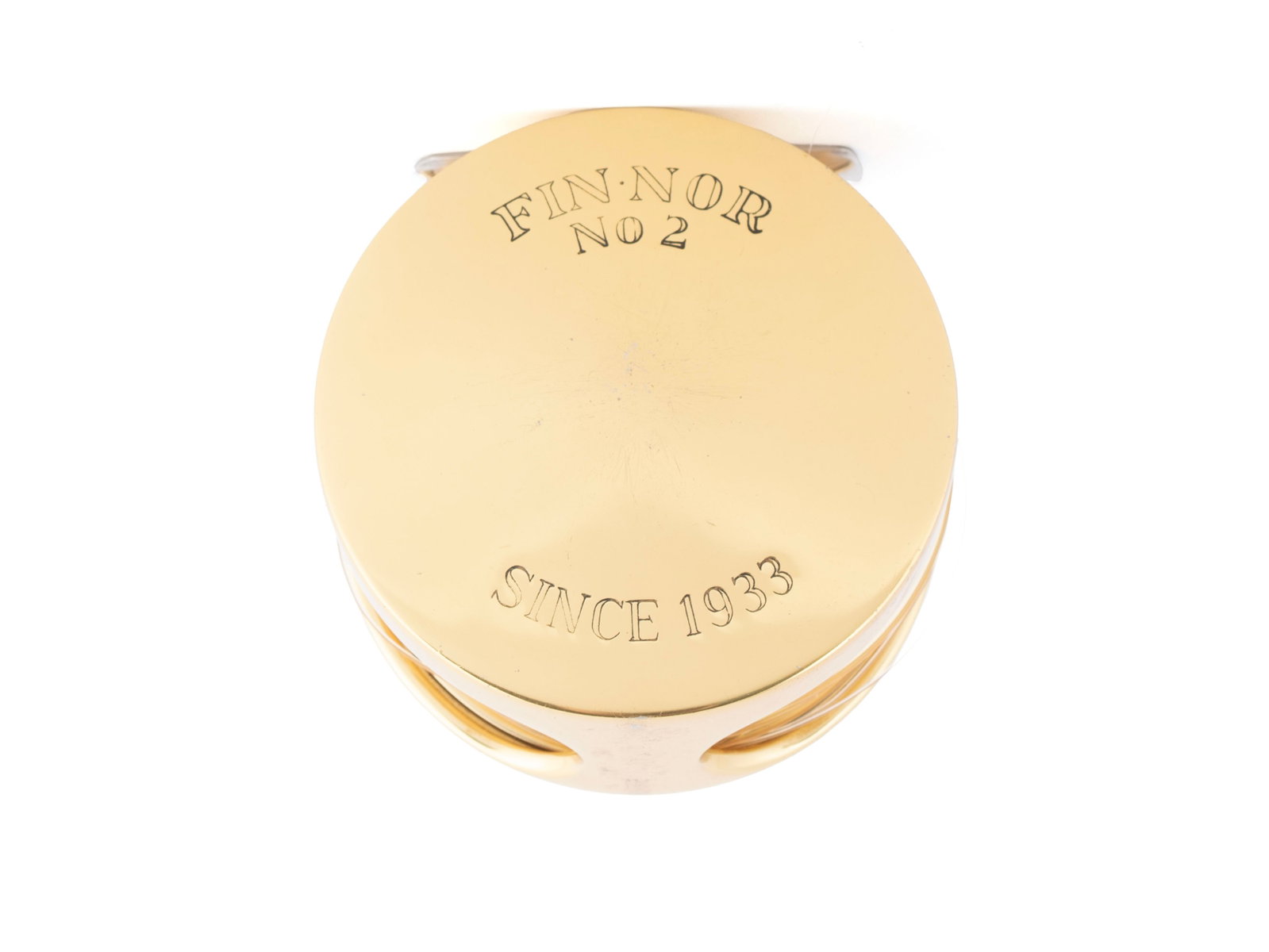 FIN-NOR NO 2 GILT METAL FISHING REEL: FIN-NOR NO 2 GILT METAL FISHING REEL American, 20th century. Etched to bright gold colored casing. 2 3/4 x 3 1/4 in. (7 x 8.3 cm.)