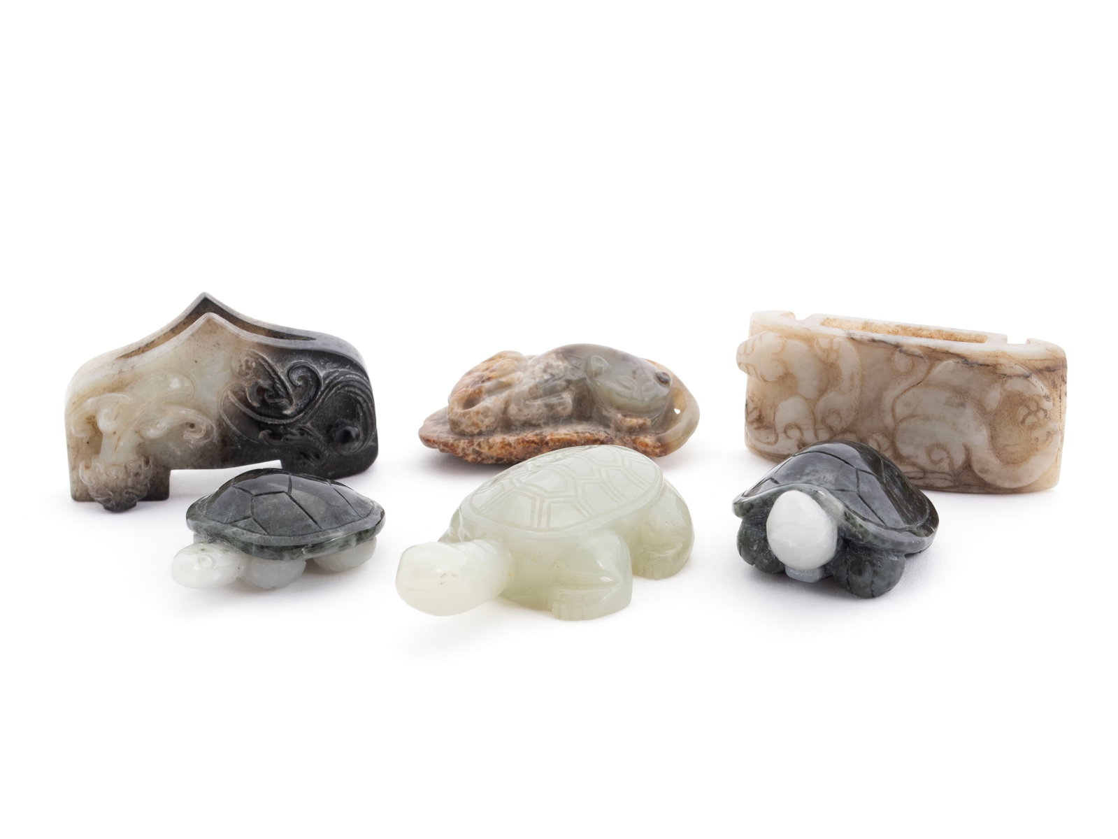 SIX CHINESE HARDSTONE CARVINGS: SIX CHINESE HARDSTONE CARVINGS A Chinese carved Warring States scabbard slide and an archaic carved sword guard. Along with three (3) carved turtles, and toad figure group. Largest: 2 3/4 x 1 3/4 in.