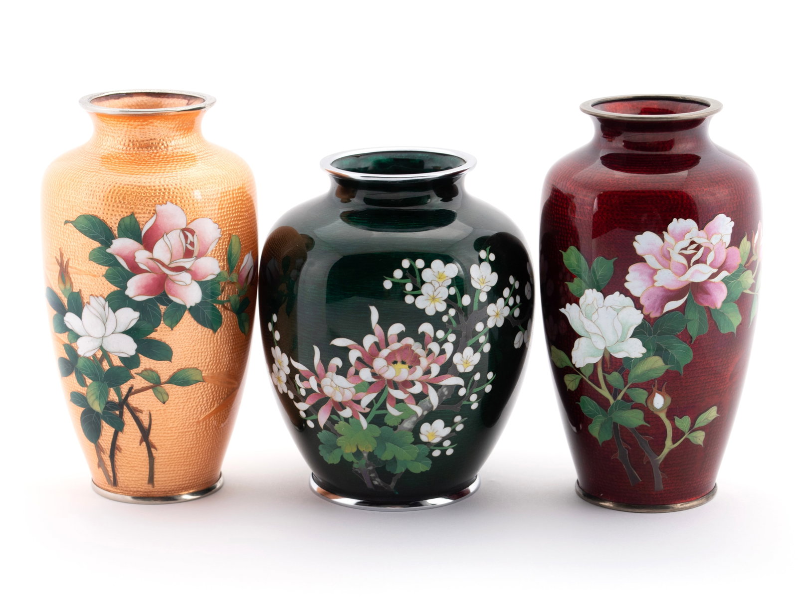 THREE GINBARI CLOISONNE ENAMEL VASES: THREE GINBARI CLOISONNE ENAMEL VASES Japanese, 20th century. All with assorted floral decoration, one with oxblood red ground, another peach ground, the last with forest green ground, all with foil