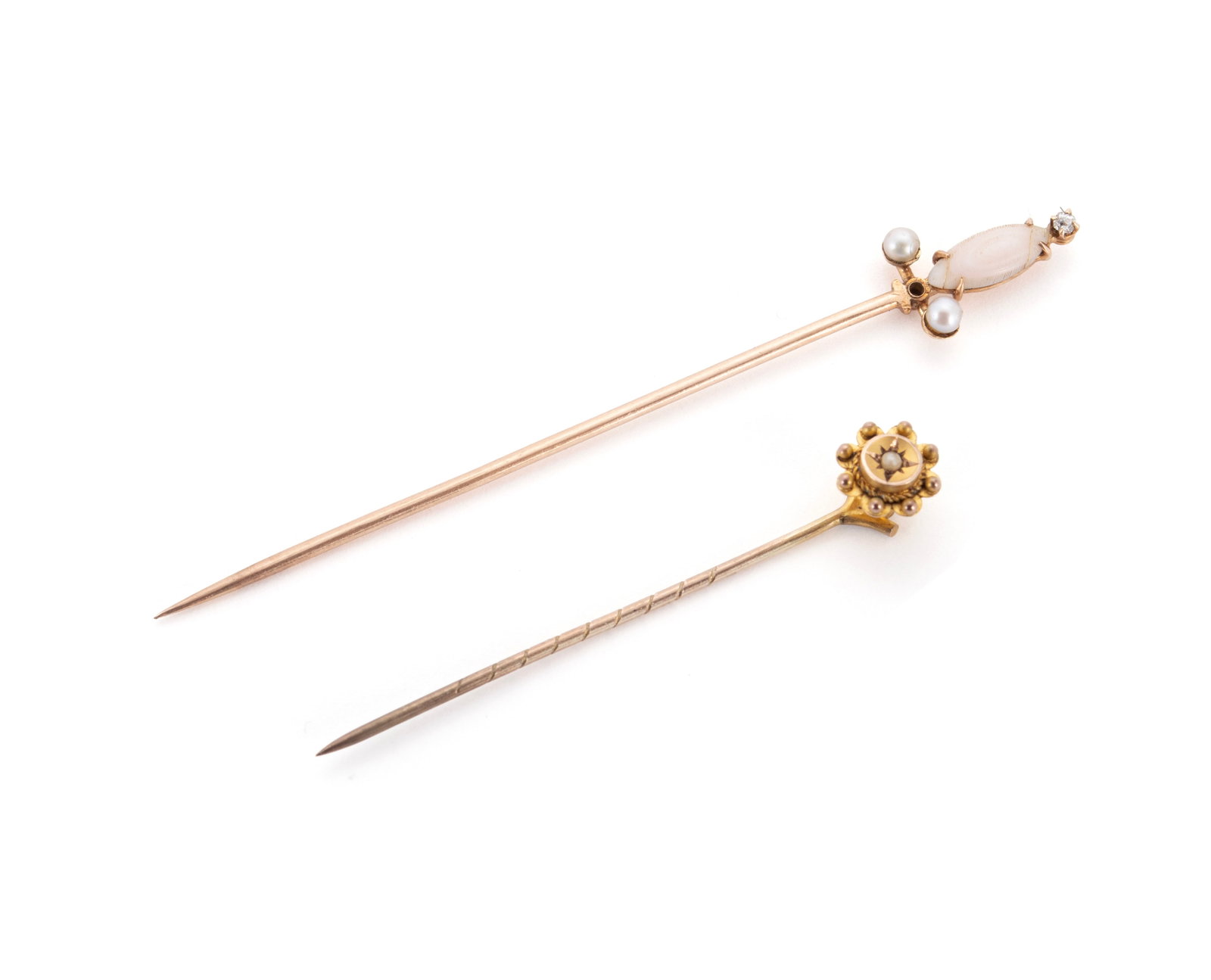 TWO GOLD ANTIQUE STICK PINS: TWO GOLD ANTIQUE STICK PINS One 14k gold of sword form set with a marquise shape angel skin coral, two seed pearls, and a single diamond, unmarked (acid test). One 9ct (marked) with a detachable