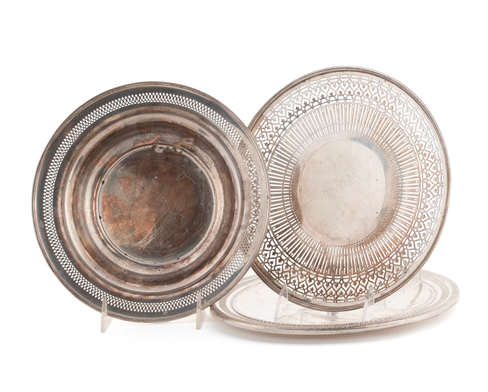 THREE STERLING SILVER DISHES: THREE STERLING SILVER DISHES American, 20th century. Including two (2) pierced plates (one by Tiffany & Co.) and a bowl, all marked. Total weight 805 grams Largest plate: 9 3/4 in. (24.8 cm.)