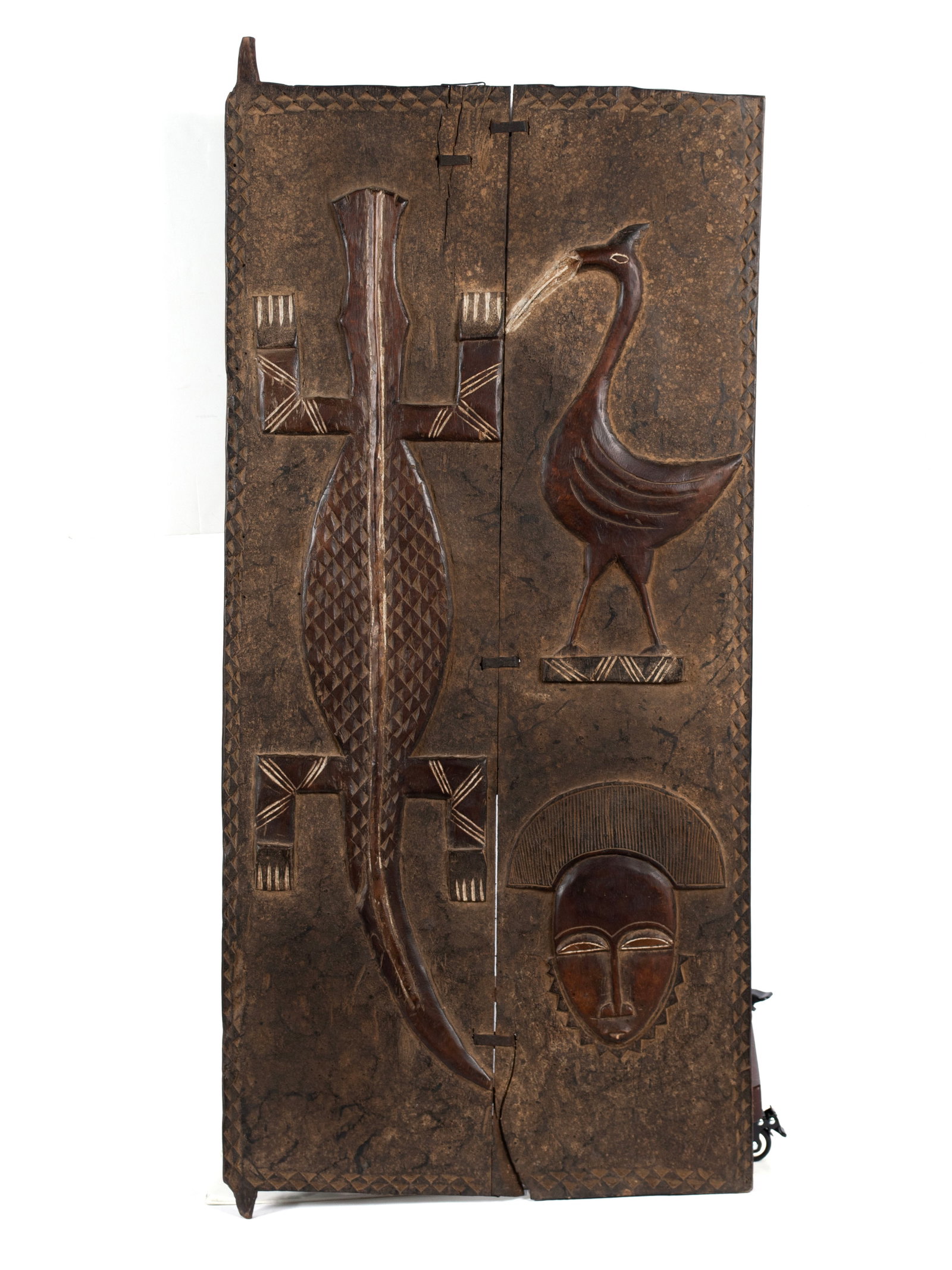BAULE GRAINARY DOOR PANEL: BAULE GRAINARY DOOR PANEL Ivory Coast (C?te d'Ivoire), West Africa, 20th century. The two-board door carved with alligator and a bird image with a mask near the bottom. 57 x 26 in. (144.8 x 66 cm.)
