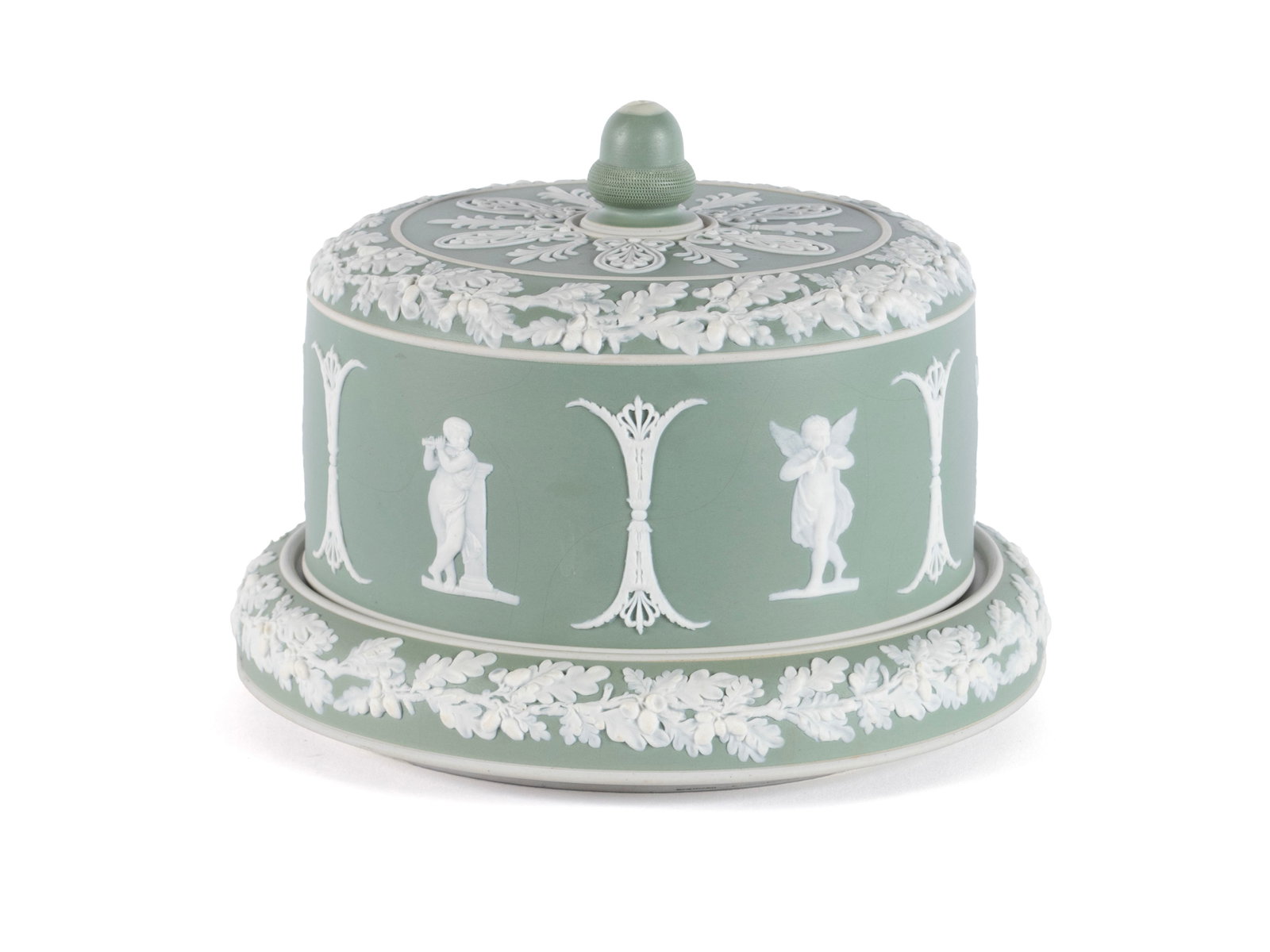 JASPERWARE CHEESE KEEPER WITH UNDERPLATE: JASPERWARE CHEESE KEEPER WITH UNDERPLATE English, 19th/20th century. Cameo decoration throughout with acorn filled foliate vines, angelic figures along the side and an acorn finial, on the