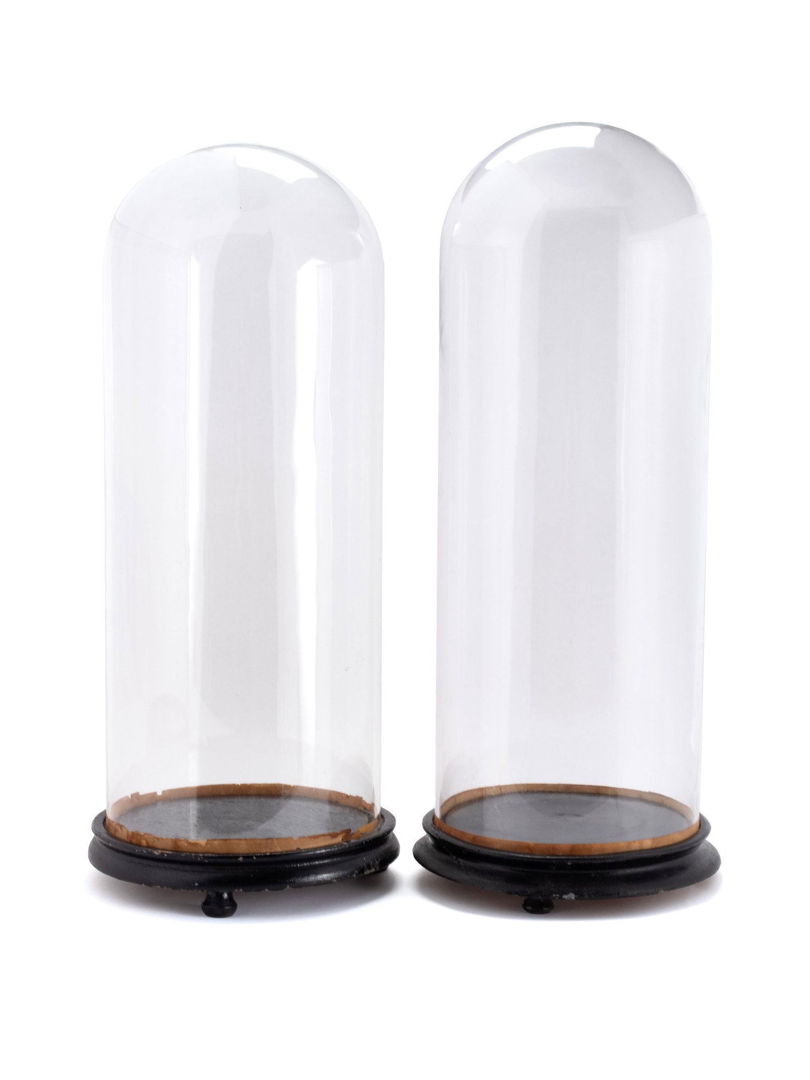 PAIR OF TALL GLASS DOMES: PAIR OF TALL GLASS DOMES Continental, early 20th century. Clear glass display domes on fitted circular wooden stands. 21 x 7 1/4 in. (53.3 x 18.4 cm.)