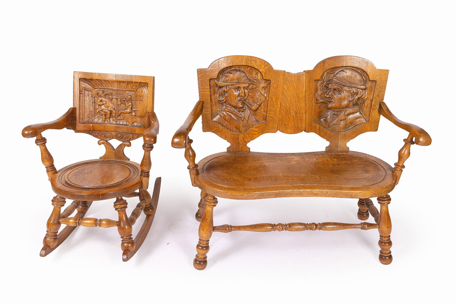 GEORGE ARNDT OAK TAVERN LOVESEAT AND ROCKER: GEORGE ARNDT OAK TAVERN LOVESEAT AND ROCKER American, early 20th century. The loveseat with profile portrait carvings to the back, the rocker showing a pub scene of two men drinking, with turned