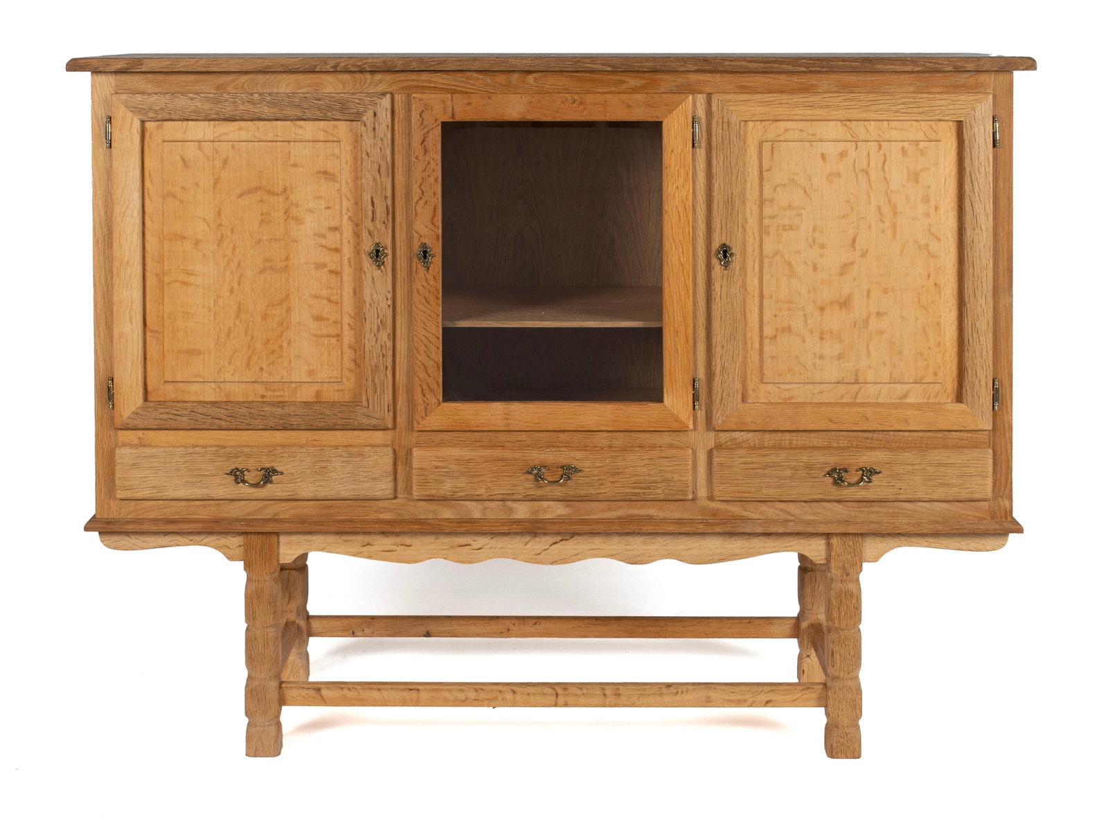 HENNING KJAERNULF FOR HUNDSTRUP MOBELFABRIK BUFFET: HENNING KJAERNULF FOR HUNDSTRUP MOBELFABRIK BUFFET Danish, 20th century, oak. Central glazed door over a shelved interior, flanked by panel doors with three drawers below, on segmented legs with