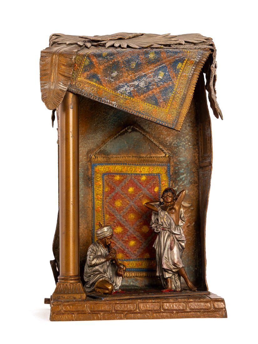 ORIENTALIST FIGURAL LAMP IN THE MANNER OF FRANZ BERGMAN: ORIENTALIST FIGURAL LAMP IN THE MANNER OF FRANZ BERGMAN Austrian, circa 1920, cold painted, electric. Carpet salesman with carpets draped over the roof, back wall and floor, a semi-nude woman