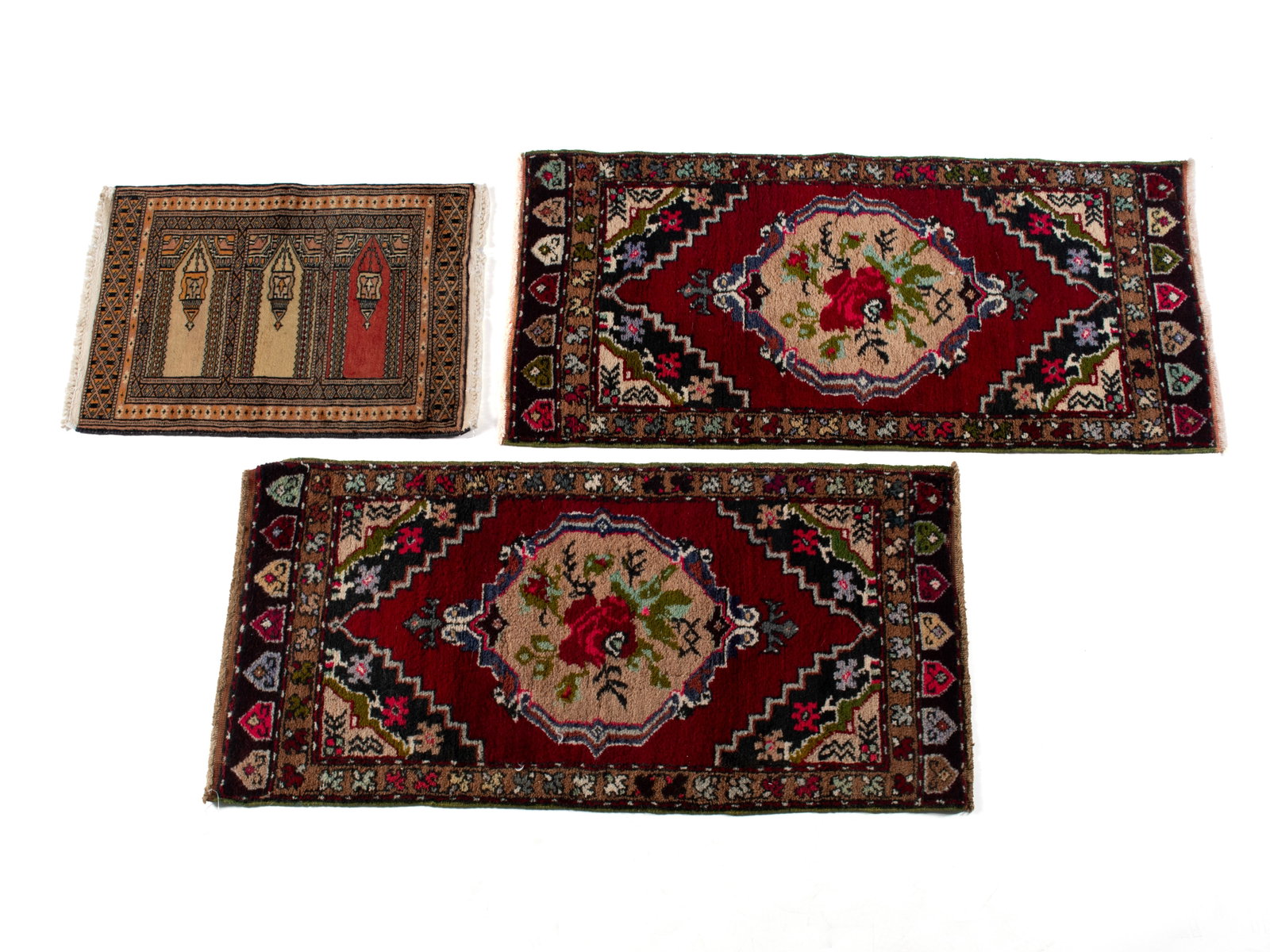 PAIR OF TURKISH THROW RUGS AND A SAFF MAT: PAIR OF TURKISH THROW RUGS AND A SAFF MAT Turkish, 20th century. Roses center the beige medallions to the open red fields of the pair, with layered corners, gold borders with thin guard borders and