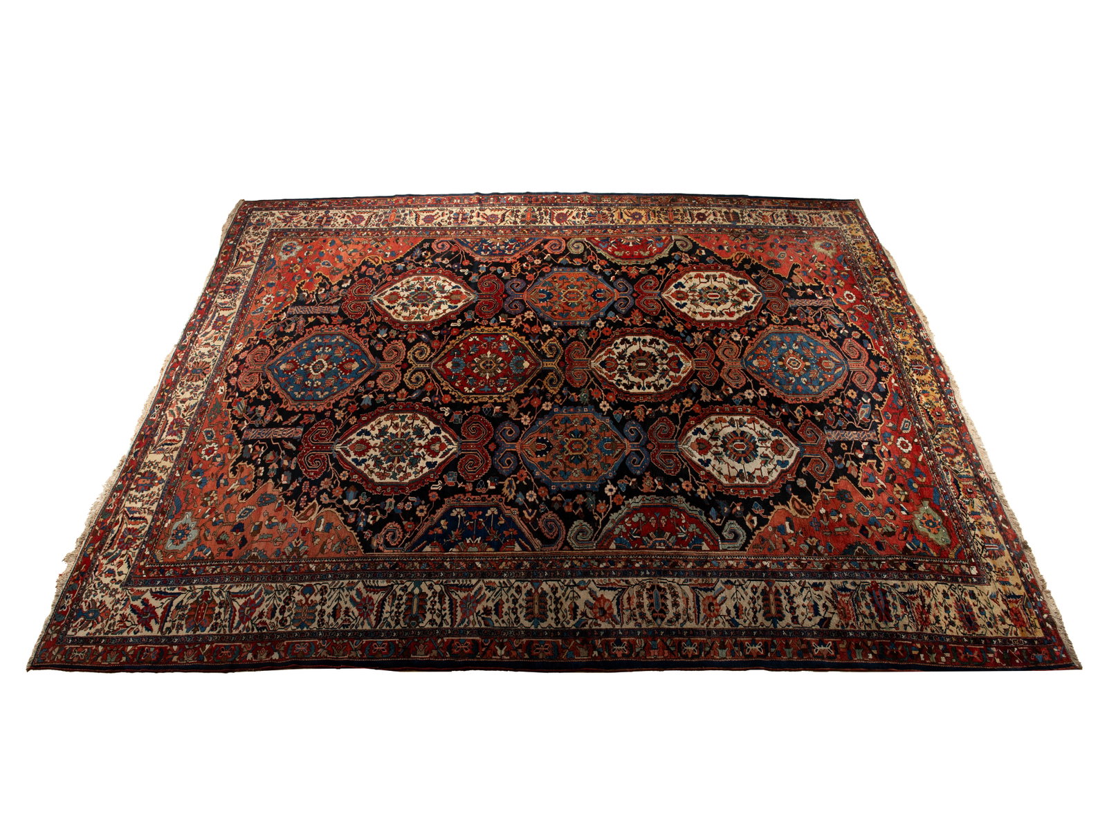 BAHKTIARI ROOM RUG: BAHKTIARI ROOM RUG Persian, 2nd quarter 20th century. Large colorful foliate decorated medallions across the floral decorated navy field with red corners, with an abrash ivory primary border with