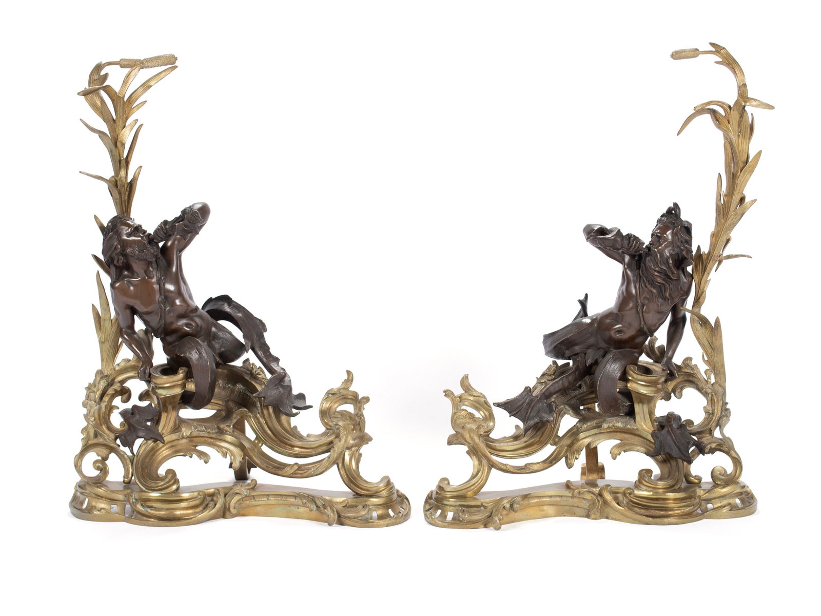 PAIR OF LOUIS XV STYLE FIGURAL CHENETS: PAIR OF LOUIS XV STYLE FIGURAL CHENETS Continental, 19th century, bronze with gilt patinated highlights. Each showing a mythical triton figure blowing a horn (shell), seated on the gilt scrolling