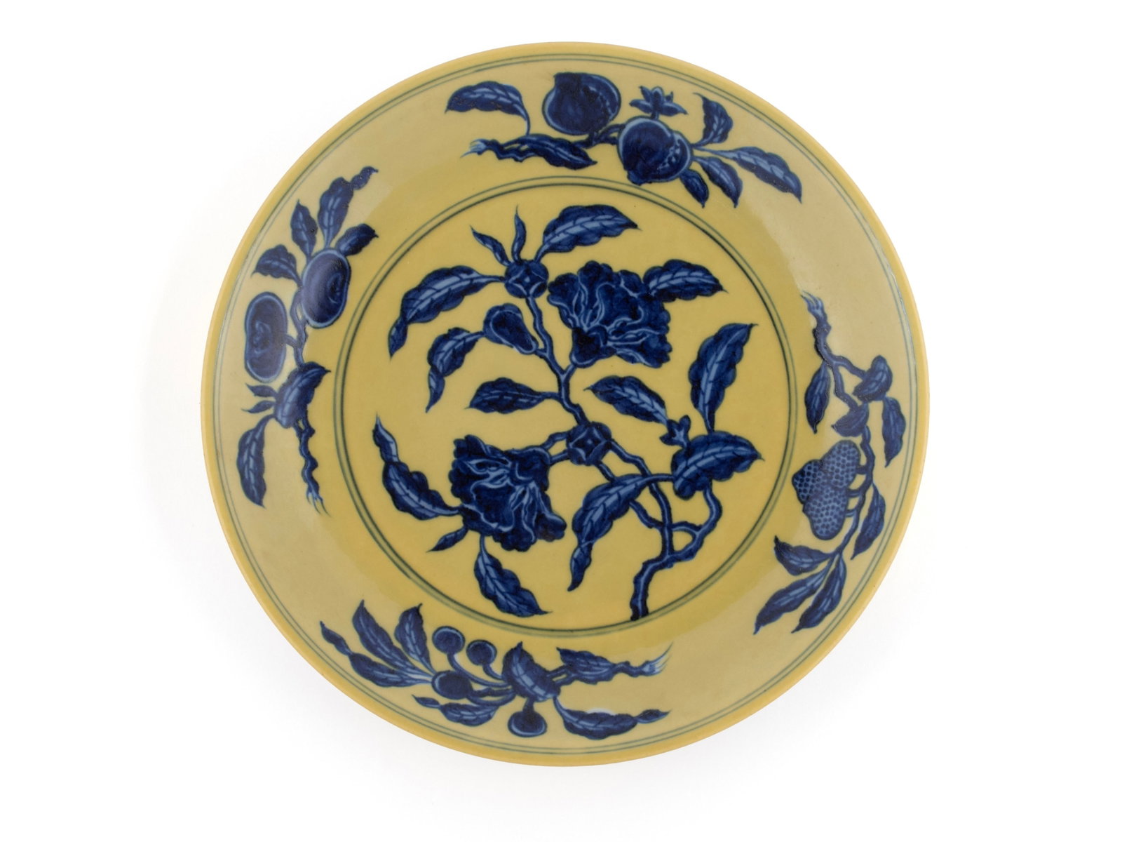 MING STYLE YELLOW-GROUND BLUE AND WHITE POMEGRANATE DISH: MING STYLE YELLOW-GROUND BLUE AND WHITE POMEGRANATE DISH China, Xuande style dish, painted in under-glaze blue with central pomegranate branch, the cavetto showing fruiting sprays of peach,