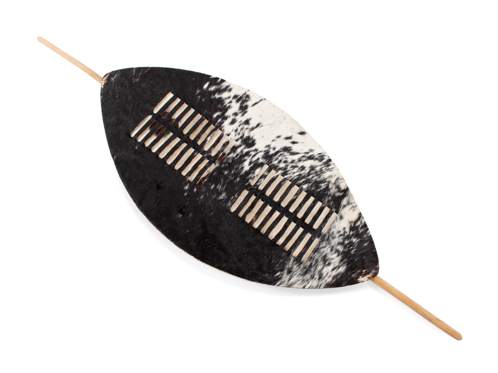 ZULU ISIHLANGU SHIELD: ZULU ISIHLANGU SHIELD South African, 20th century. War shield of cow hide covered in dark brown and white fur. Shield: 30 x 16 in. (76.2 x 40.6 cm.), Fully: 47 x 16 in. (119.4 x 40.6 cm.)