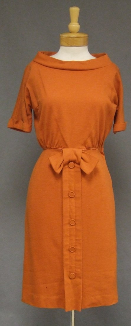 Minx Modes Pumpkin Wool Knit 1950's 1960's Day Dress: A FABULOUS 1950's or 1960's day dress in a pumpkin colored wool knit. Wide neckline. Cuffed short sleeves. Piped waistband with large bow. Button trimmed, fitted skirt. Rear metal zipper. Lined. "Minx