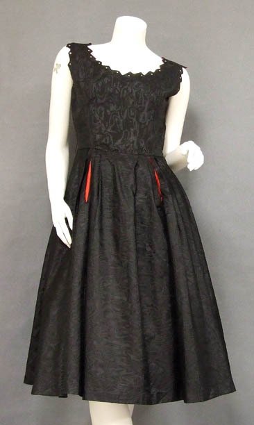 Black Moire Taffeta 1950's Cocktail Dress RS Red Trim: A wonderful 1950's cocktail dress in a black moire taffeta. Sleeveless bodice with rhinestone dotted sawtooth neckline. Dress has a semi-full skirt with cherry red acetate lined slit pockets. Belt loo