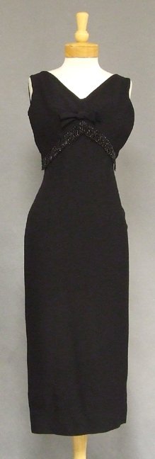 Black Crepe 1960s Evening Dress w/ Bead Fringe: A nice 1960's evening dress in a medium weight black rayon crepe. Fitted dress with an attached overblouse trimmed in dangling bead fringe. Self fabric bow on bust. Proportions look a bit odd on the f