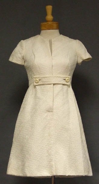 Chic Ivory Brocade Sarmi 1960s Cocktail Dress: A chic 1960s cocktail dress in an ivory brocade. Hidden side seam pockets. Lined. Concealed snap closures down the front of the dress. "Designed by Sarmi New York," label. Size: 33" bust, 26" waist, 3