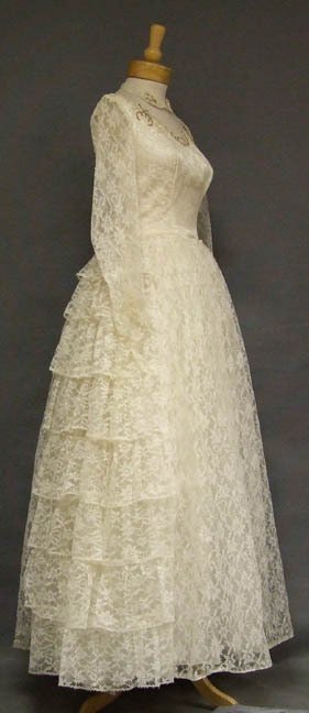 Ivory Lace Vintage Wedding Gown w/ Tiered Side Panels: A beautiful wedding gown in ivory lace. Fitted bodice with sheer long sleeves, sheer yoke and dark faux pearl/sequin accents at the neckline/collar. Gown has a very full tulle lined skirt with tiered 