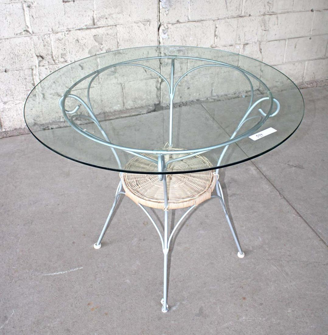 Metal/wicker base glass top bistro table: Metal and wicker base glass top bistro table approx. 36" diameter x 30" h