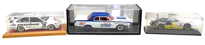 3 diecast cars in display cases