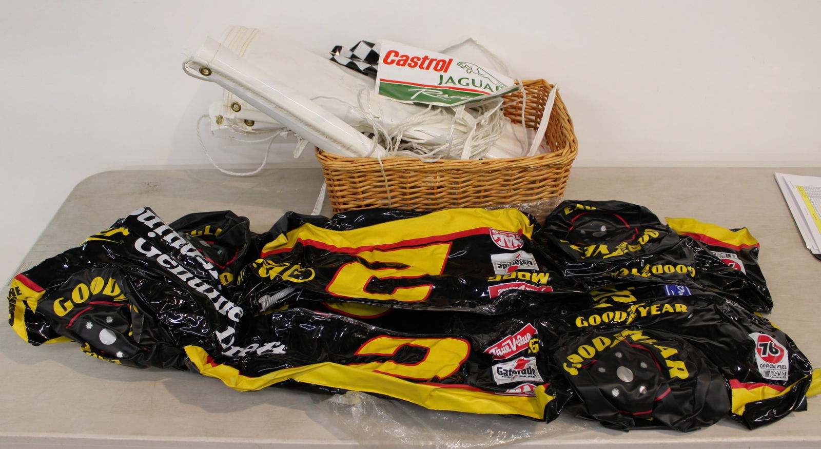 Mixed lot basket of race car banners, NASCAR racing memorabilia, inflatable car (1 of 1)