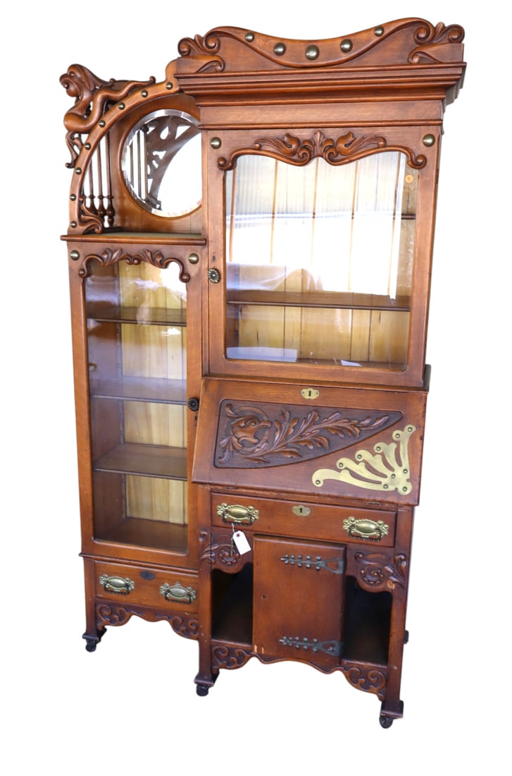 Antique oak highly carved secretary double bookcase: Antique oak highly carved secretary double bookcase with beveled glass round mirror and brass accents, nice model, original finish, structurally sound and in good condition for age. 80.5"h x 45"w x 19