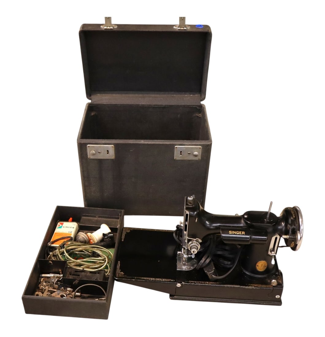 Vintage Singer 221 Centennial Sewing Machine Case: 1951 Centennial Singer 221 Featherweight machine with anniversary badge. Complete with pedal and accessory tray filled with attachments and oil can. Case missing leather handle. 12"Hx13"Wx8"D.