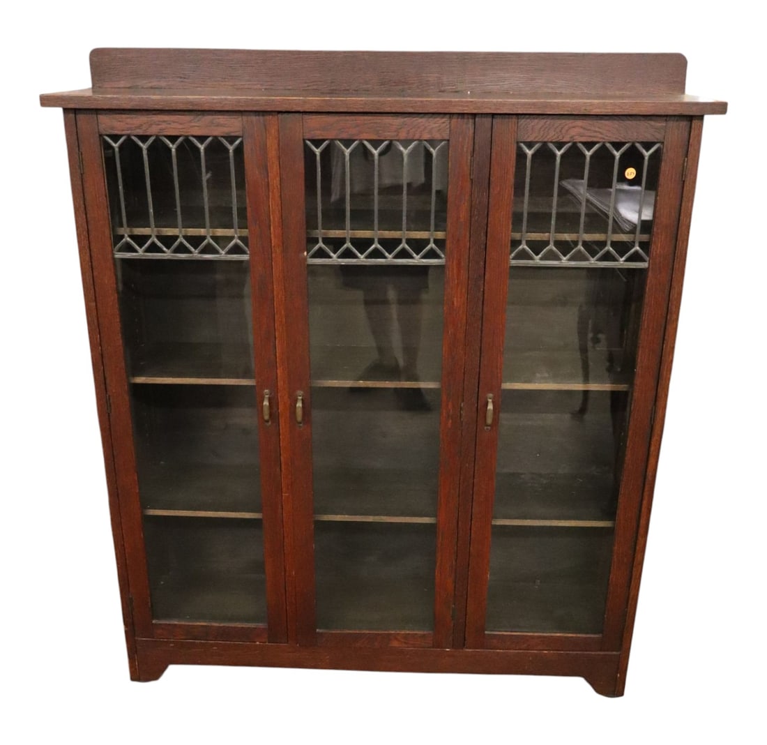 Antique Arts & Crafts Oak 3-Door Leaded Bookcase: Antique arts & crafts oak 3 door lead glass bookcase, original finish, structurally sound and in good condition with adjustable 9 wood shelves with staining on top. 54.5"h x 48.5"w x 13"d