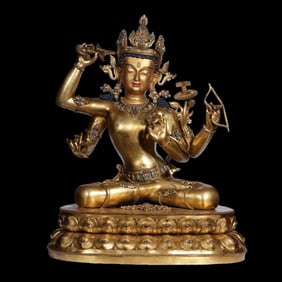 A Qing Dynasty gilt bronze four-armed Guanyin statue inlaid with gemstones