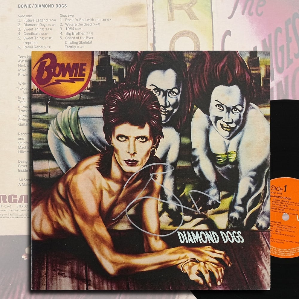 DAVID BOWIE SIGNED "DIAMOND DOGS" LP (U.K. FIRST PRESSING): 12 1/4 x 12 1/4 in Released in 1974, Diamond Dogs stands among David Bowie's most influential albums, bridging the theatrical glam rock of his Ziggy Stardust era with the darker, more experimental