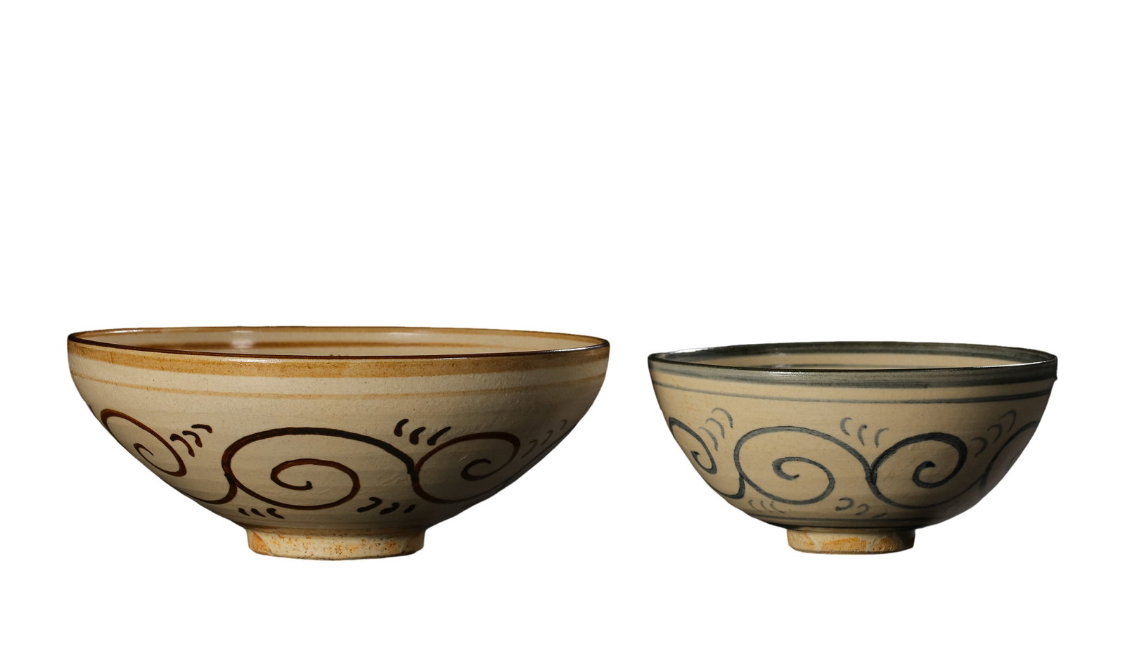 Song Dynasty Cizhou Kiln White Slip Iron-Brown & Ink Lotus Pattern Conical Bowls, Pair: Dimensions?Larger bowl mouth diameter 15.2 cm (6.0 in), height 6.2 cm (2.4 in); Smaller bowl mouth diameter 11.5 cm (4.5 in), height 5.5 cm (2.2 in), 10th–13th Century CECondition & Provenance?This 