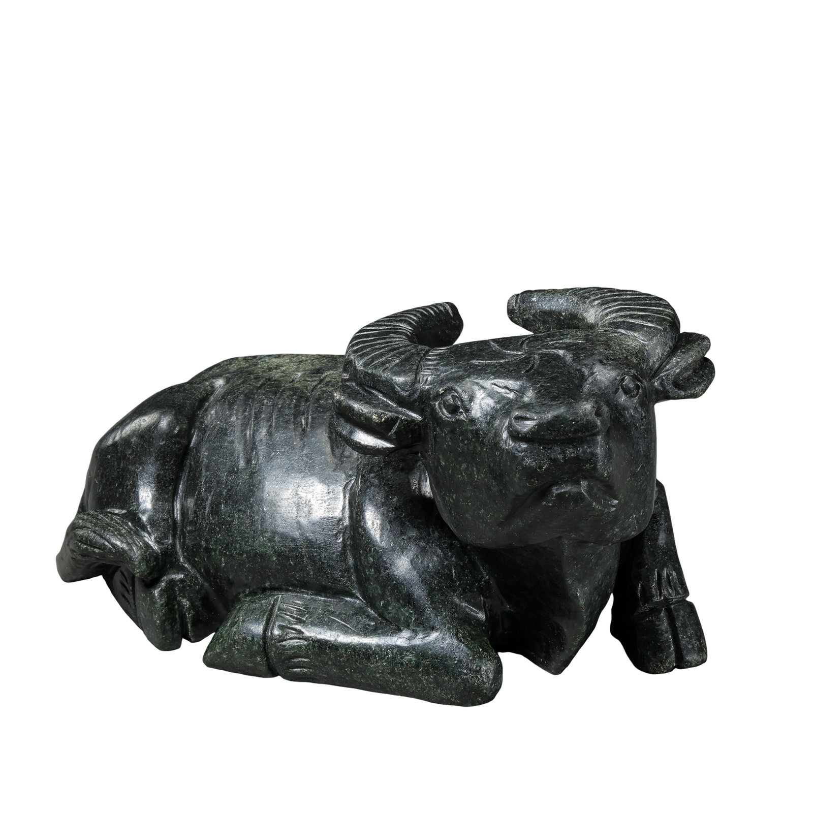 Carved Dark Green Jade Recumbent Buffalo, Qing Dynasty: Dimensions:Length 18cm (7?1/8in), Height 8.5cm (3?3/8in), Weight 1763gCondition & Provenance:This heavy jade buffalo figure maintains solid structural integrity with no major cracks, deep chips or res