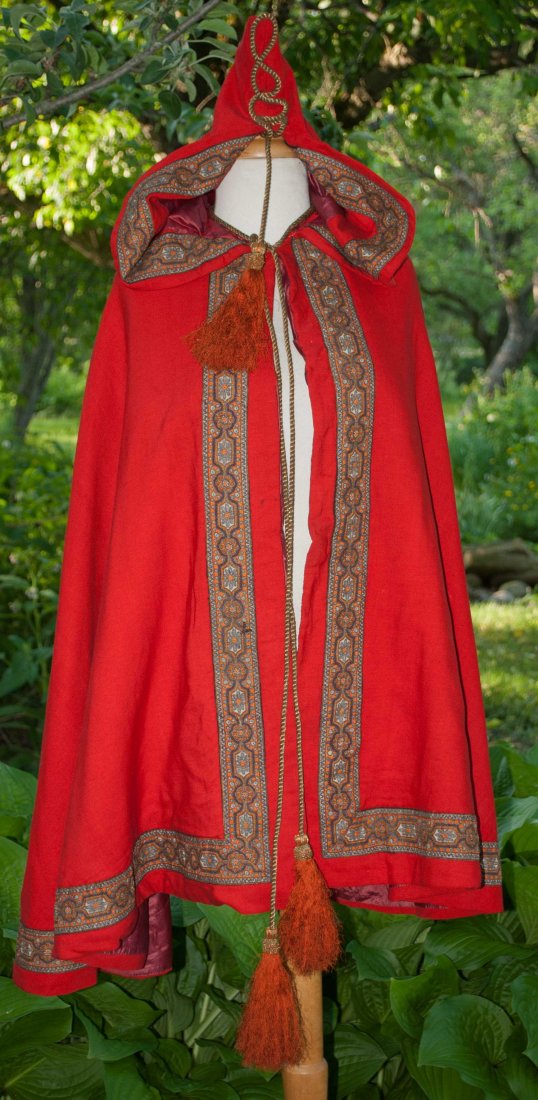 ANTIQUE RED WOOL HOODED CAPE 1850: ANTIQUE RED WOOL HOODED CAPE 1850 METALLIC TRIM WITH TASSELS Presenting a mid 19th century hooded red wool cape. Fancy and beautiful hand embroidered metallic threads ornamental designs on trim with f