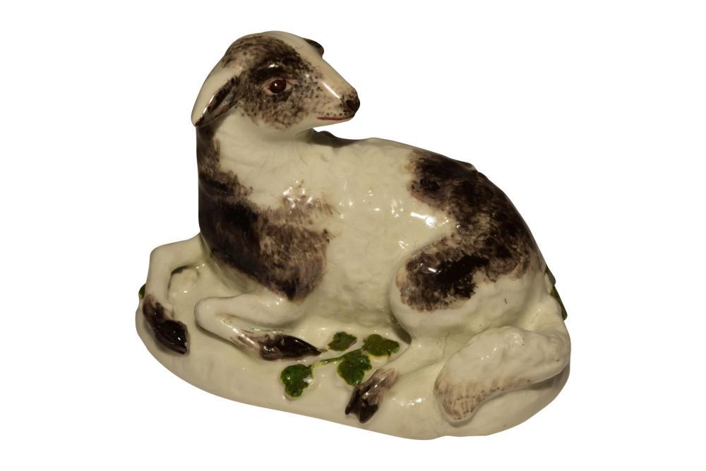 Lying sheep Meissen 1750 | "Liegendes Schaf" Meissen: Sheep lying on an oval base with black fur spots. Painting of the base with green flowers, Meissen 1750 | Auf ovalem Sockel liegendes Schaf mit schwarzen Fellflecken. Bemalung des Sockels mit grün