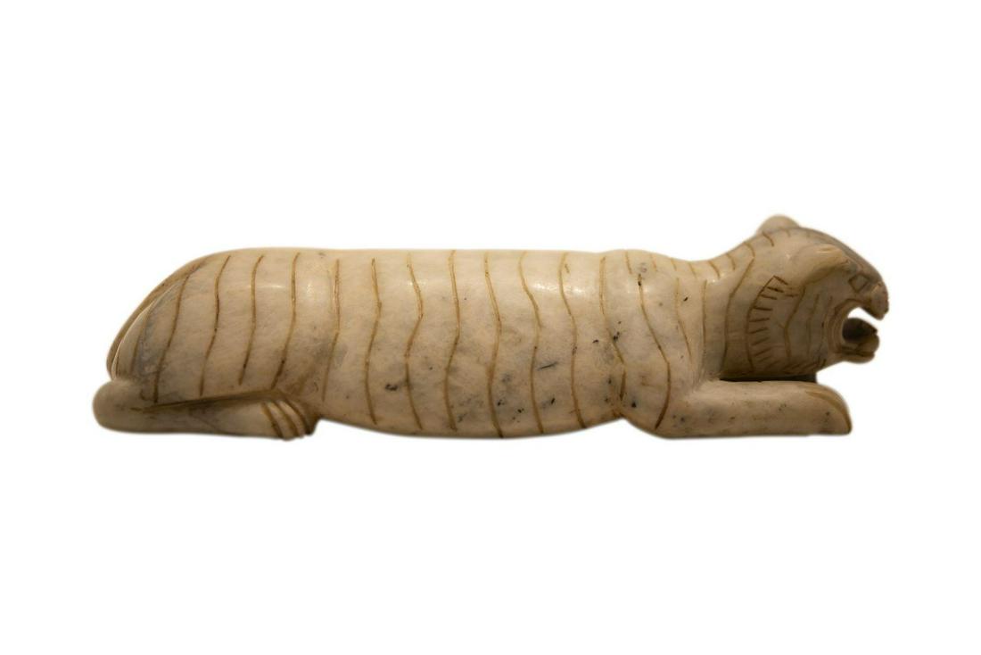 Lying Lion | Liegender Löwe: Lying lion, made of white jade, dimensions: 24.5 x 7.3 cm. | Liegender Löwe, aus weißer Jade, Maße: 24,5 x 7,3 cm.